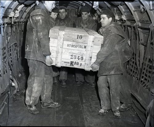 Workers unload food from an airplane.