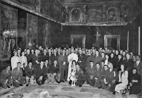 Around 100 members of the military and their wives pose for a group photo with Pope Pius XII.