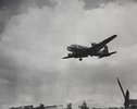 A low flying plane drops candy with parachutes.