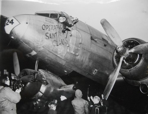 Ein als Weihnachtsmann verkleideter Pilot verteilt nach der Landung in Tempelhof Geschenke aus seinem Flugzeug.